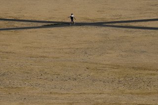 Un homme marche sur l'herbe brûlée de Greenwich Park à Londres en août 2022.